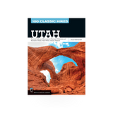 A hardcover book titled "100 Classic Hikes Utah" by Mountaineers Books, featuring scenic hiking trail images on the cover.