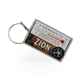 Impact Photographics compass keychain featuring a metal compass pendant with a keyring, ideal for outdoor enthusiasts.