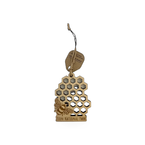 Wood ornament featuring a honeycomb pattern and bee design from Steamer Lane Design's Zion collection.