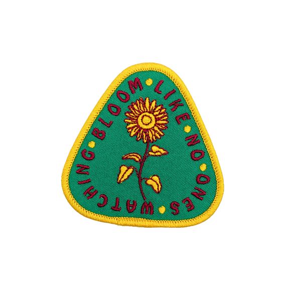 Outpatch Bloom Like No Ones Watching themed patch featuring vibrant floral design on fabric background.