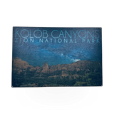Wooden sign featuring the Night Sky Kolob design by Lantern Press, with natural wood texture and celestial sky illustration.
